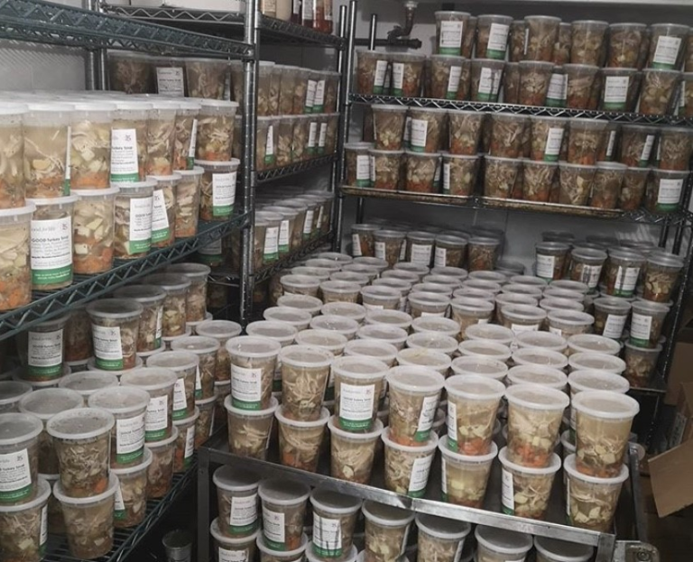 A walk in refrigerator with hundreds of containers of soup.
