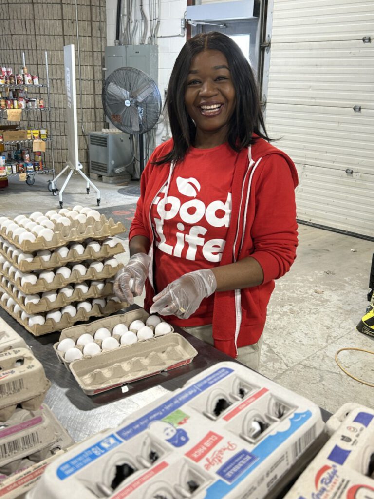 A photo of a volunteer packing eggs into cartons.