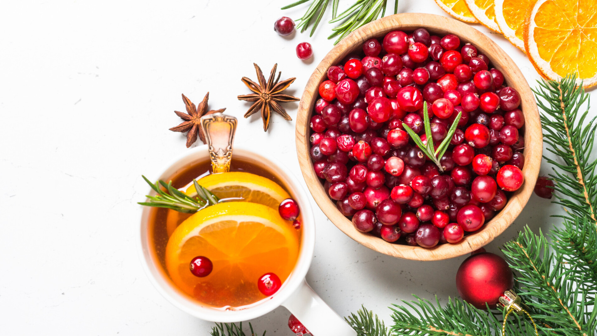 A photo of orange slices and cranberries in a bowl.